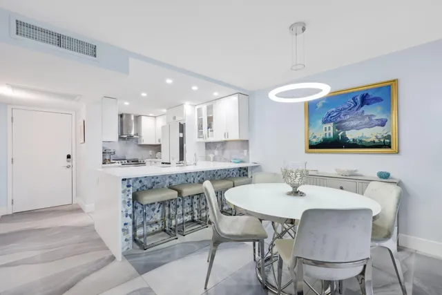 a living room with furniture a large window and a dining table