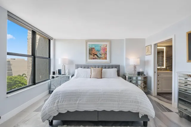 a bedroom with a bed and a flat tv screen on the dresser