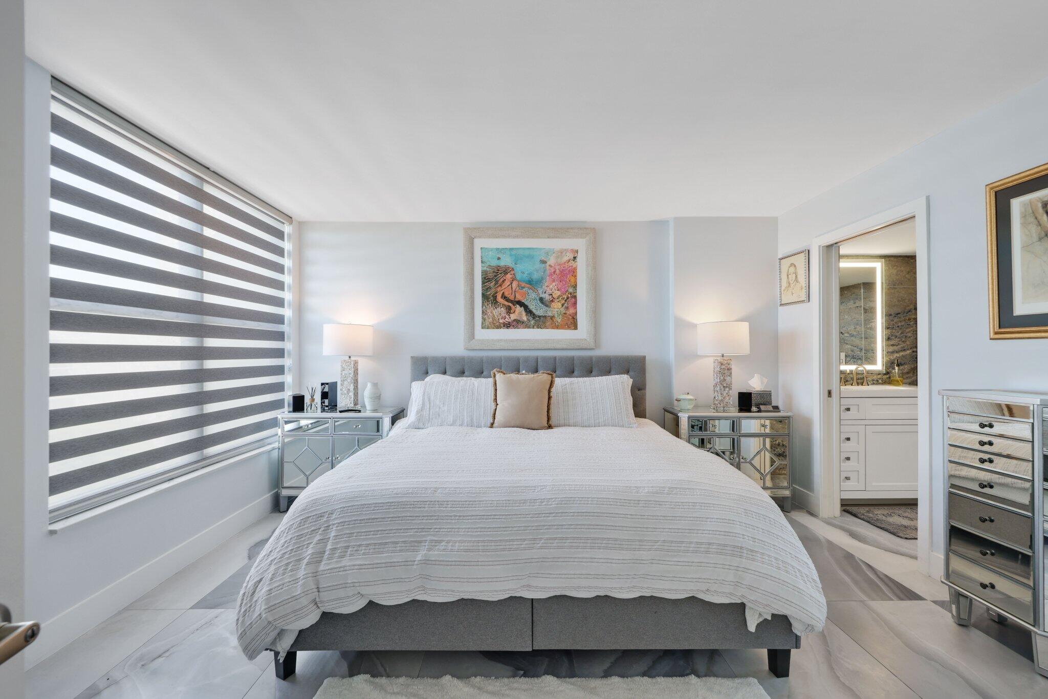 12 Royal Palm Way, Unit 605 Boca Raton, FL 33432 - Photo 21 of 47 a bedroom with a large bed and a chandelier