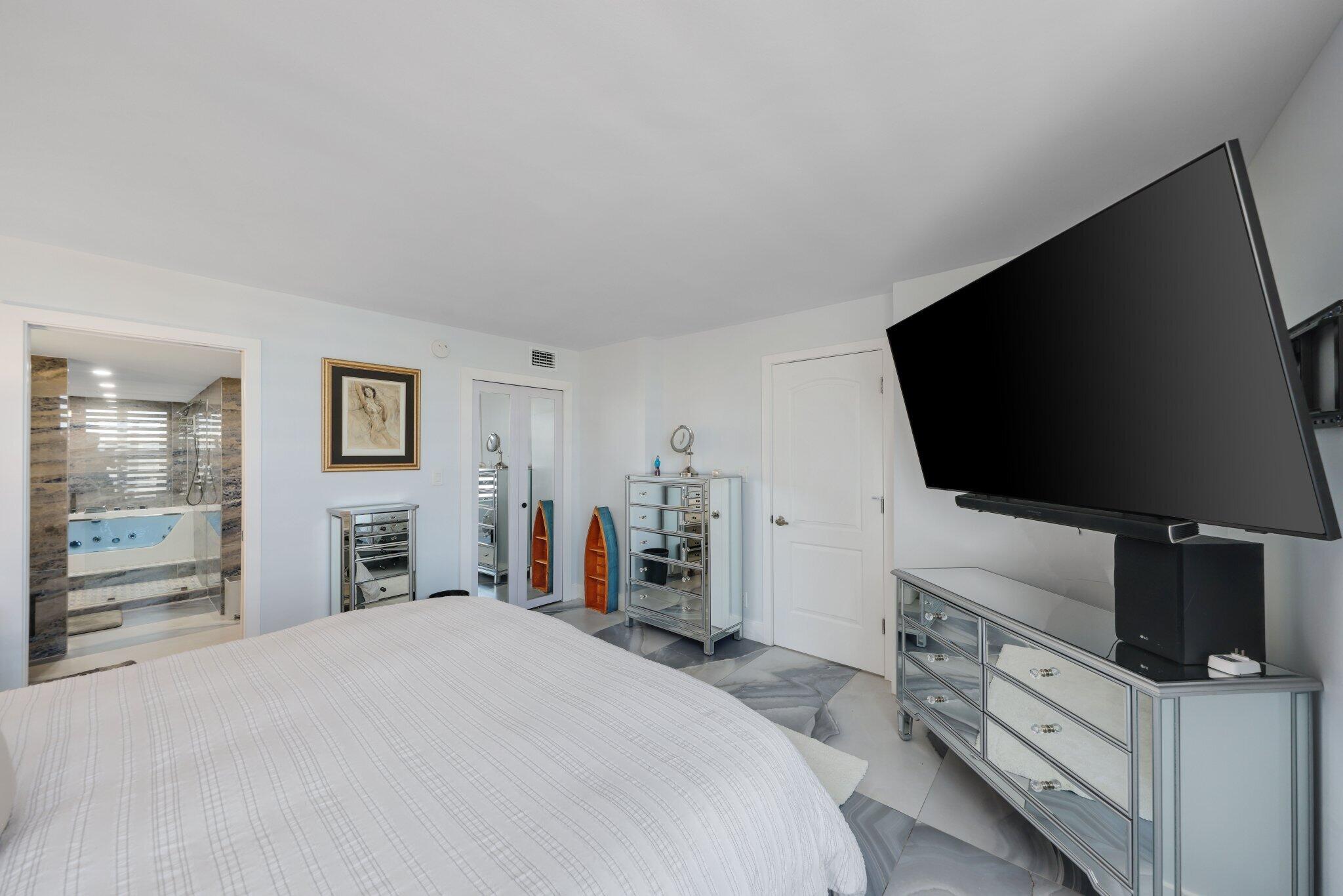 12 Royal Palm Way, Unit 605 Boca Raton, FL 33432 - Photo 23 of 47 a bedroom with furniture and a flat screen tv