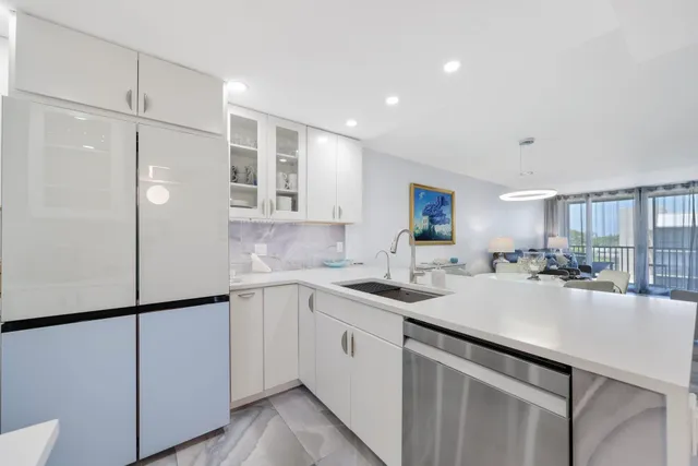 a kitchen with a sink cabinets and living room view