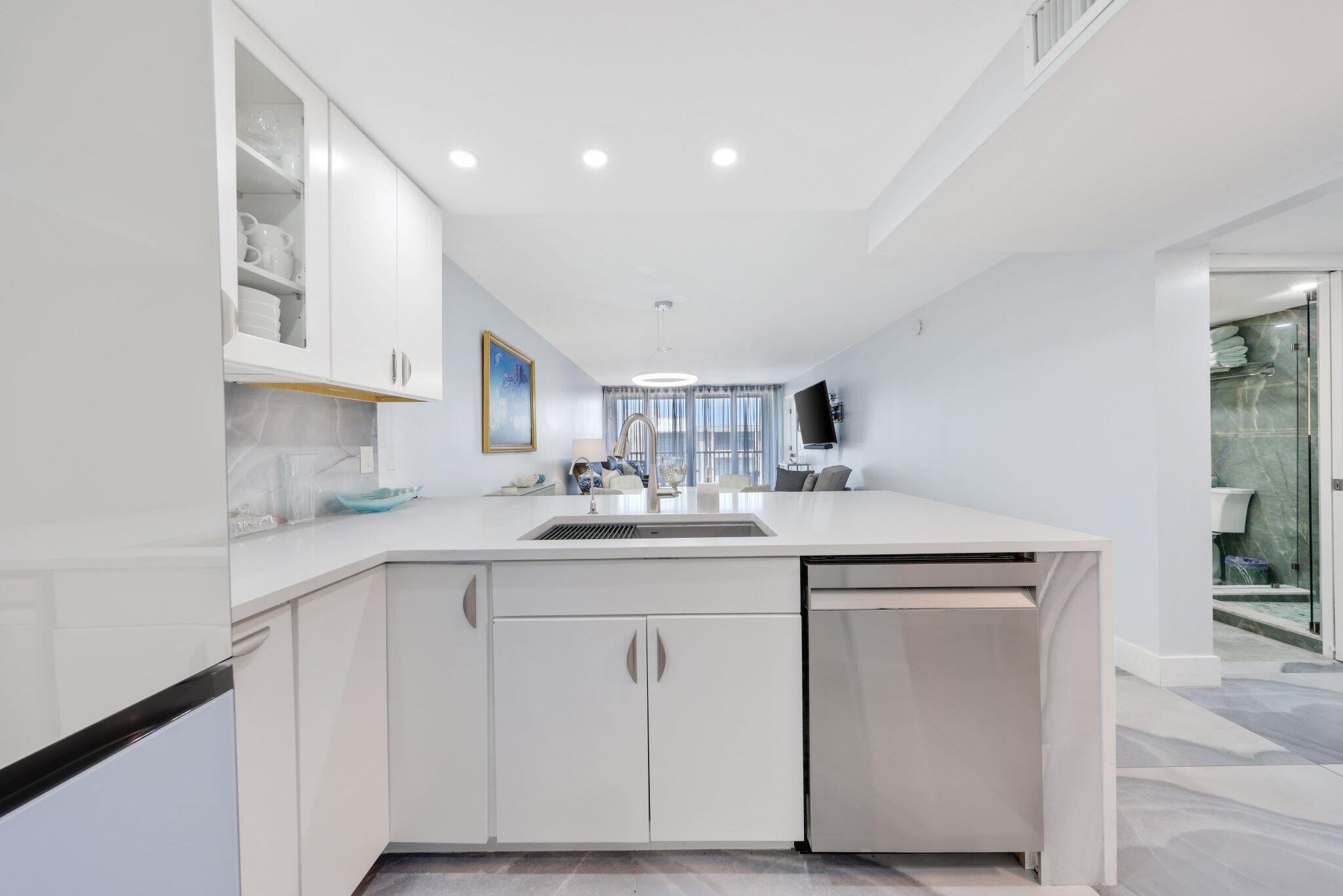 12 Royal Palm Way, Unit 605 Boca Raton, FL 33432 - Photo 8 of 47 a kitchen with white cabinets appliances and a sink