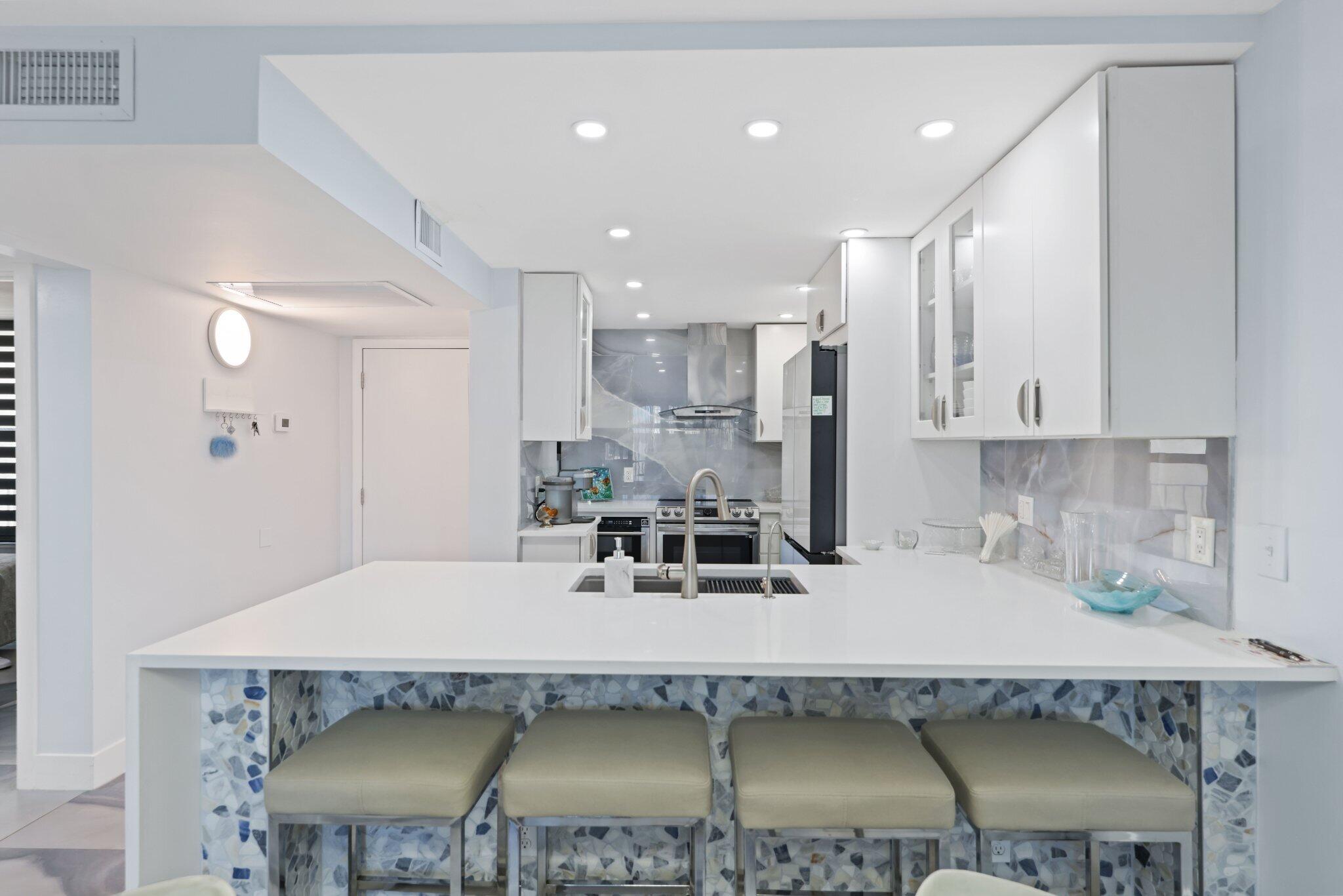 12 Royal Palm Way, Unit 605 Boca Raton, FL 33432 - Photo 10 of 47 a kitchen with a table chairs stove and kitchen view