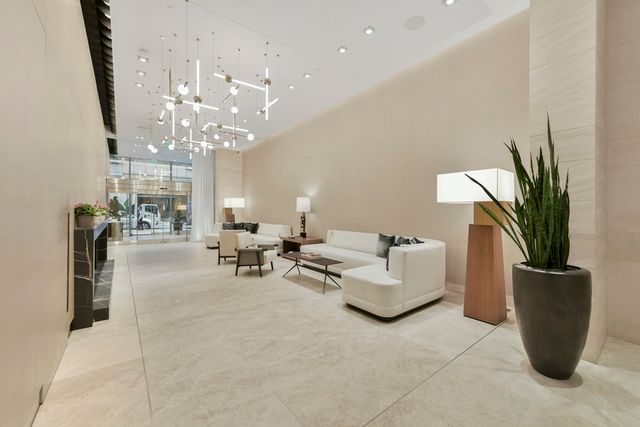 a living room with furniture a chandelier and a potted plant