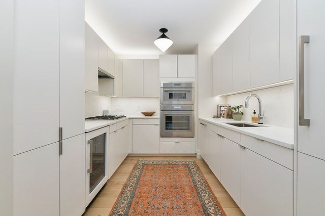 a kitchen with white cabinets and white appliances
