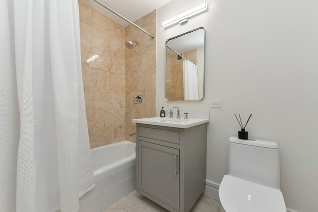 a bathroom with a toilet a sink a mirror a bathtub and vanity