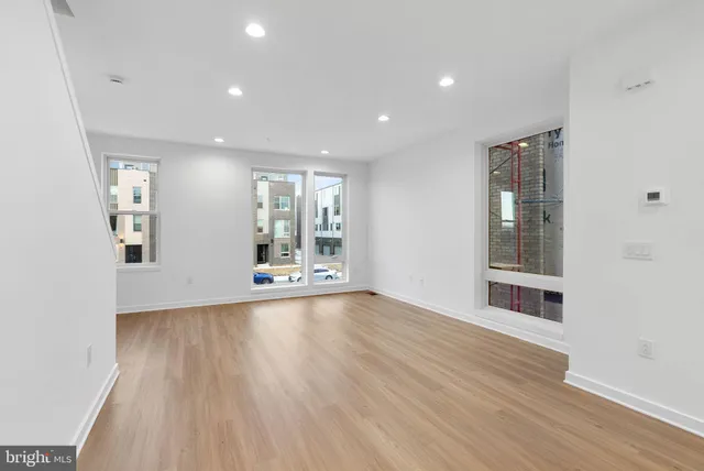 a view of a big room with wooden floor and windows