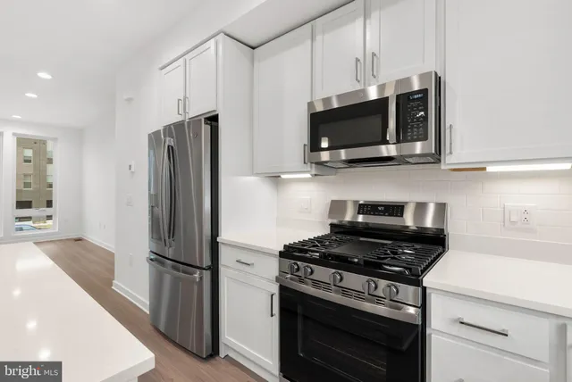 a kitchen with stainless steel appliances a refrigerator stove and microwave
