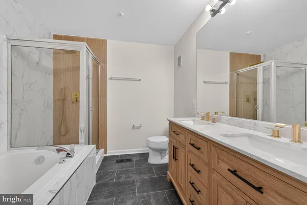 a spacious bathroom with a granite countertop tub sink a mirror a shower and a bathtub