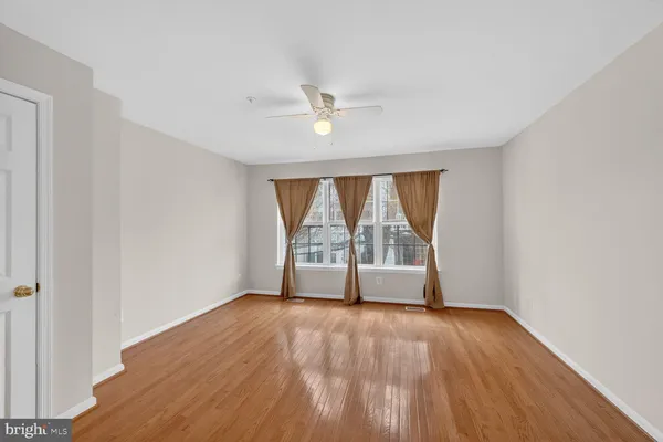 an empty room with wooden floor and balcony