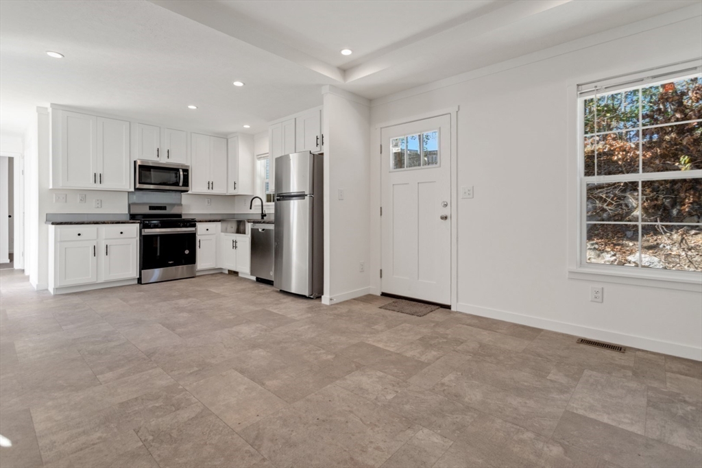 98 Newbury Street, Unit 4B Danvers, MA 01923 - Photo 16 of 32 a open kitchen with stainless steel appliances granite countertop a refrigerator and a stove top oven
