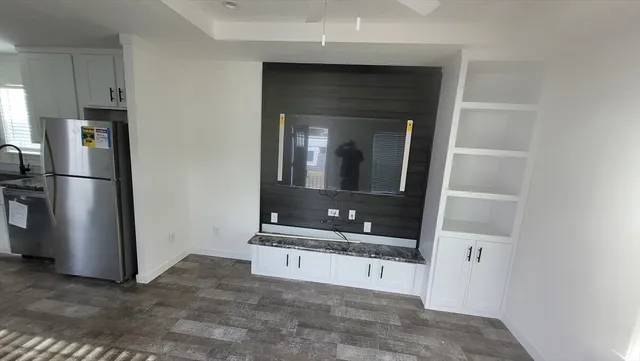 a view of an empty room and a kitchen