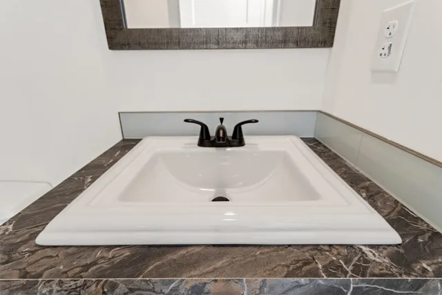 a bathroom with a sink a toilet and a mirror