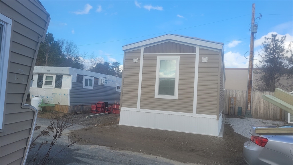 98 Newbury Street, Unit 4B Danvers, MA 01923 - Photo 28 of 32 a front view of a house with a yard