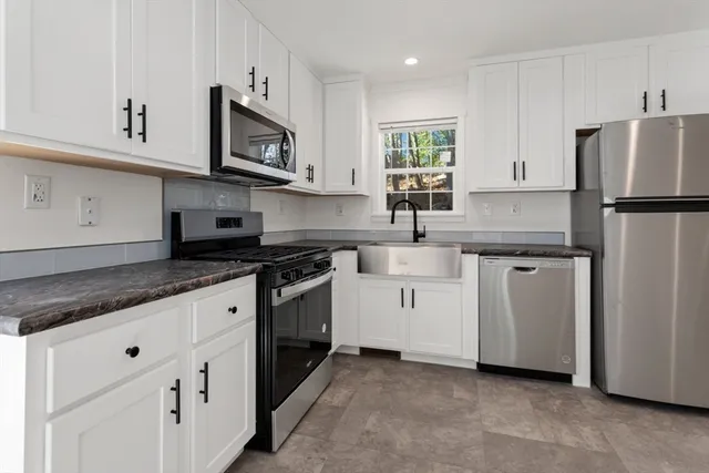 a kitchen with white cabinets sink and stainless steel appliances