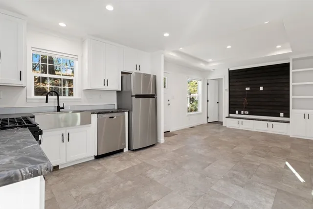 a kitchen with white cabinets and refrigerator
