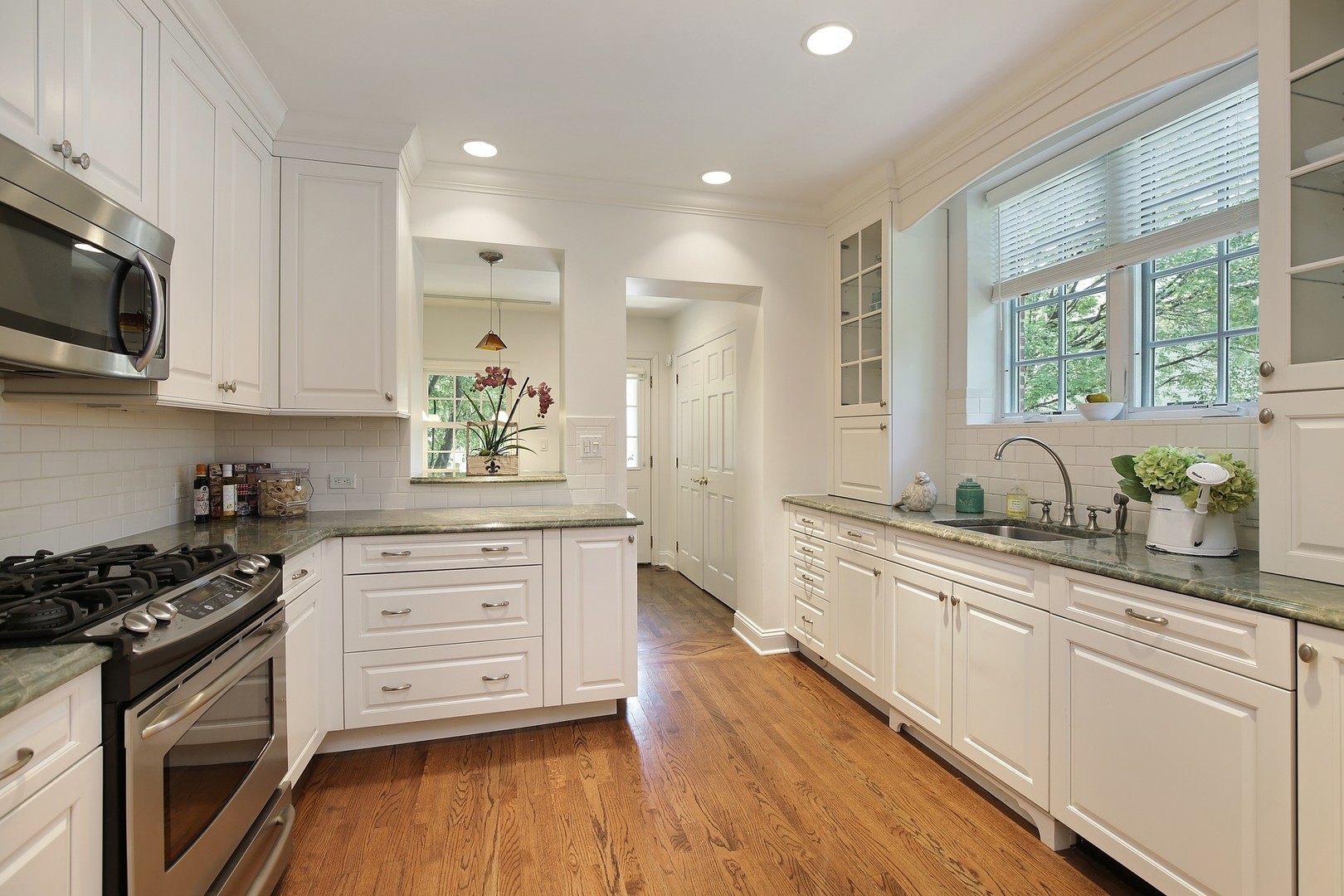 206 Sheridan Road Winnetka, IL 60093 - Photo 7 of 20 a kitchen with stainless steel appliances granite countertop white cabinets a sink a stove a microwave and wooden floors
