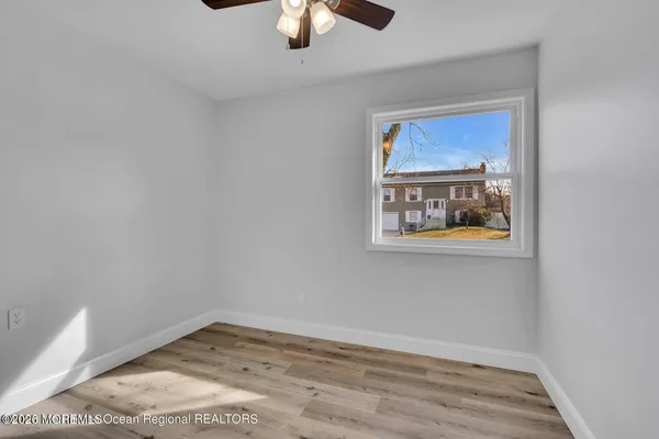 a view of a hallway with wooden floor and chandelier