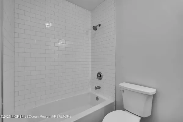 a white toilet sitting next to a bath tub