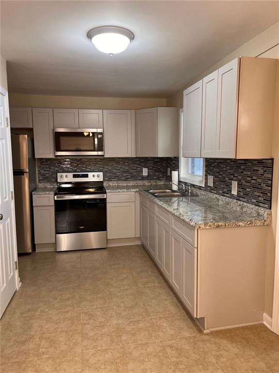3587 Fairburn Place Northwest Atlanta, GA 30331 - Photo 2 of 12 a kitchen with stainless steel appliances granite countertop a stove a sink and a microwave
