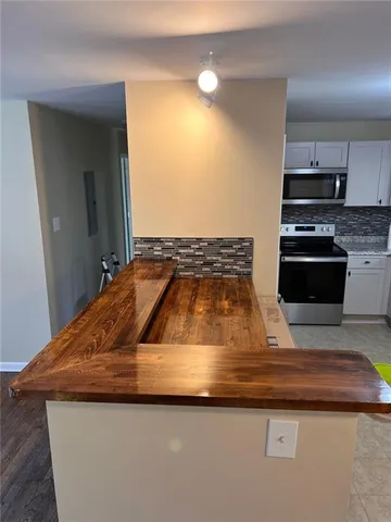 a kitchen with kitchen island granite countertop a sink and stove top oven