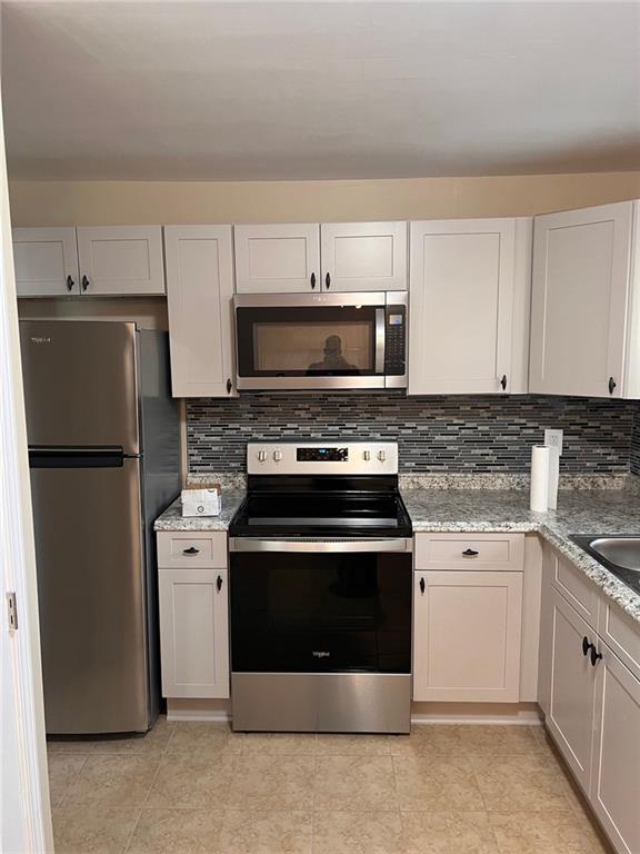 3587 Fairburn Place Northwest Atlanta, GA 30331 - Photo 4 of 12 a kitchen with a stove and a refrigerator