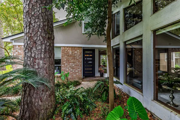 a living room with furniture a floor to ceiling window and a flat screen tv