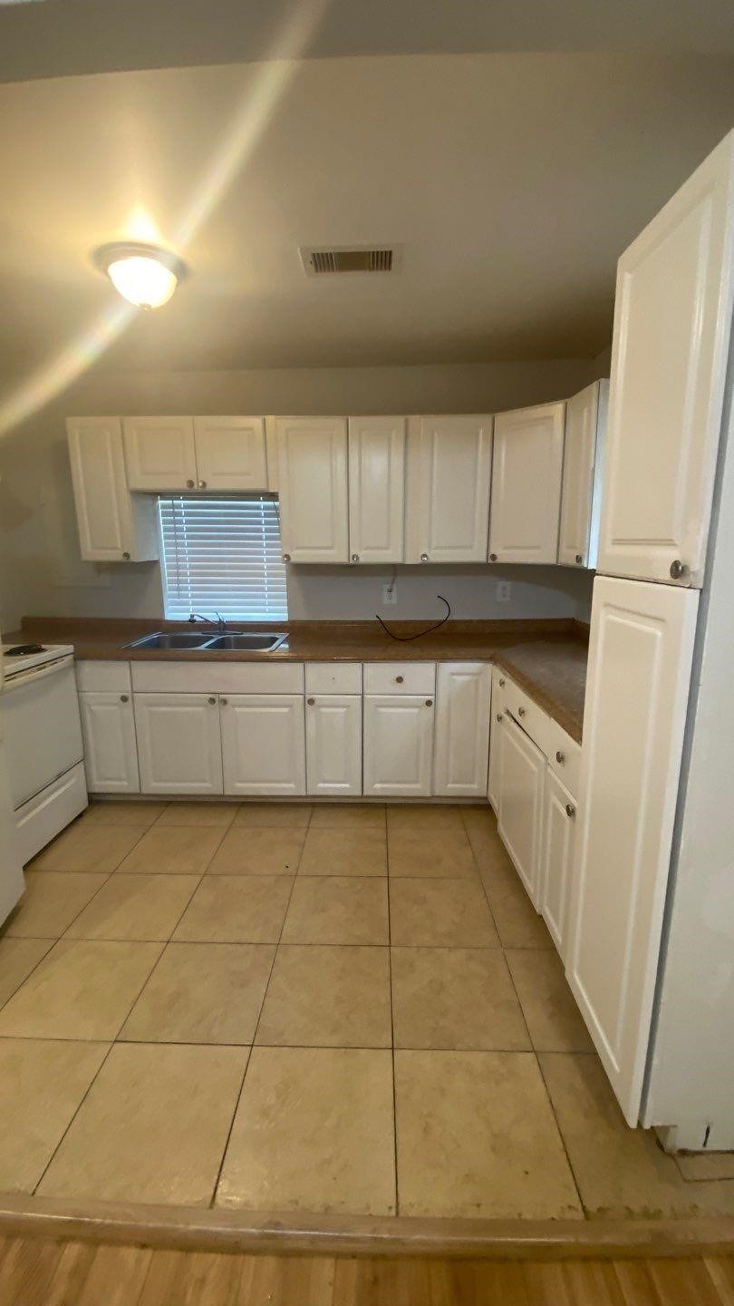 1918 Oleander La Marque, TX 77568 - Photo 4 of 20 a kitchen with granite countertop a stove a refrigerator and a sink