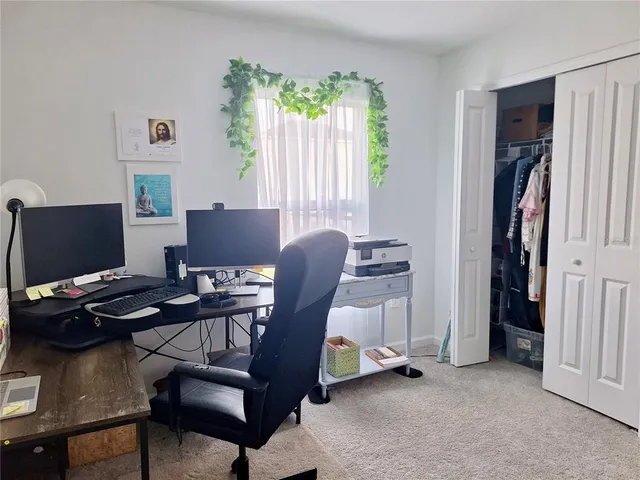 a view of a workspace with furniture and a window
