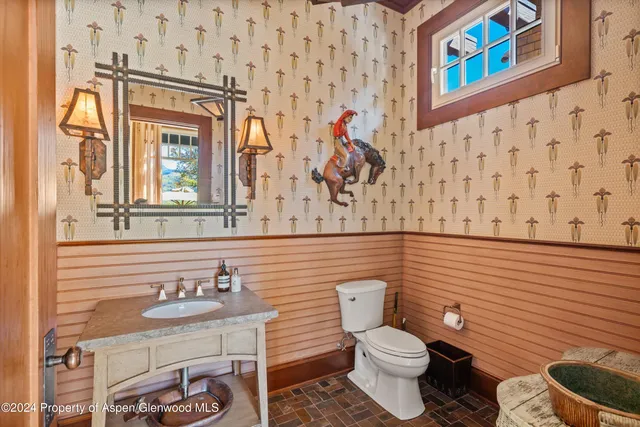 a bathroom with a granite countertop toilet sink and mirror