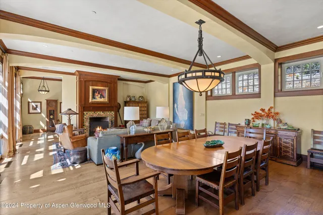 a view of a dining room and livingroom with furniture wooden floor a chandelier
