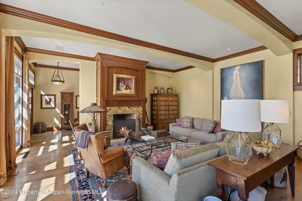 a living room with fireplace furniture and a rug