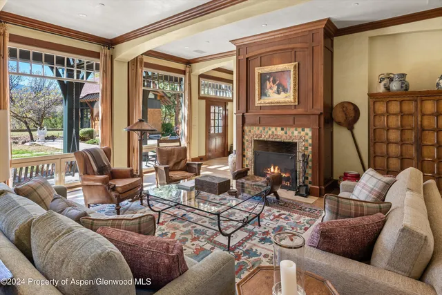 a living room with furniture fireplace and a large window