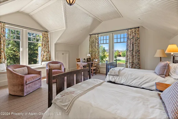 a bedroom with a bed couch and a large window
