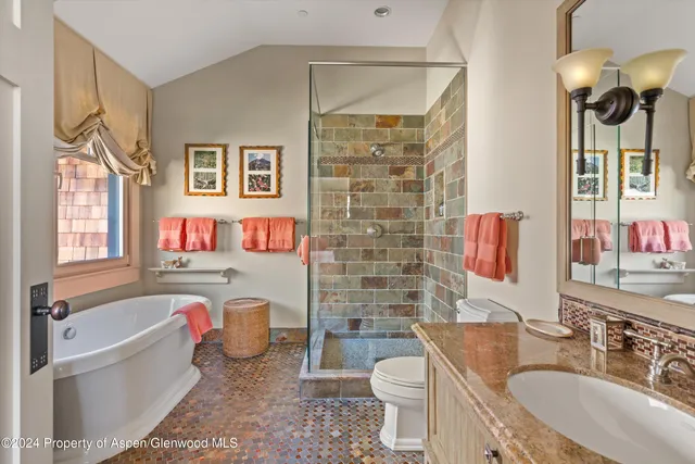 a bathroom with a granite countertop toilet sink and mirror