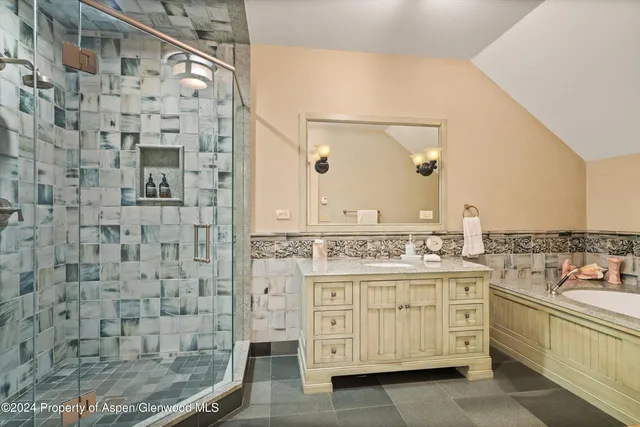 a bathroom with a granite countertop sink a toilet and shower