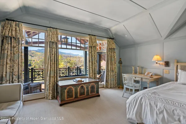 a spacious bedroom with a bed and large window