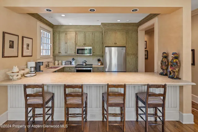 a kitchen with stainless steel appliances a table and chairs