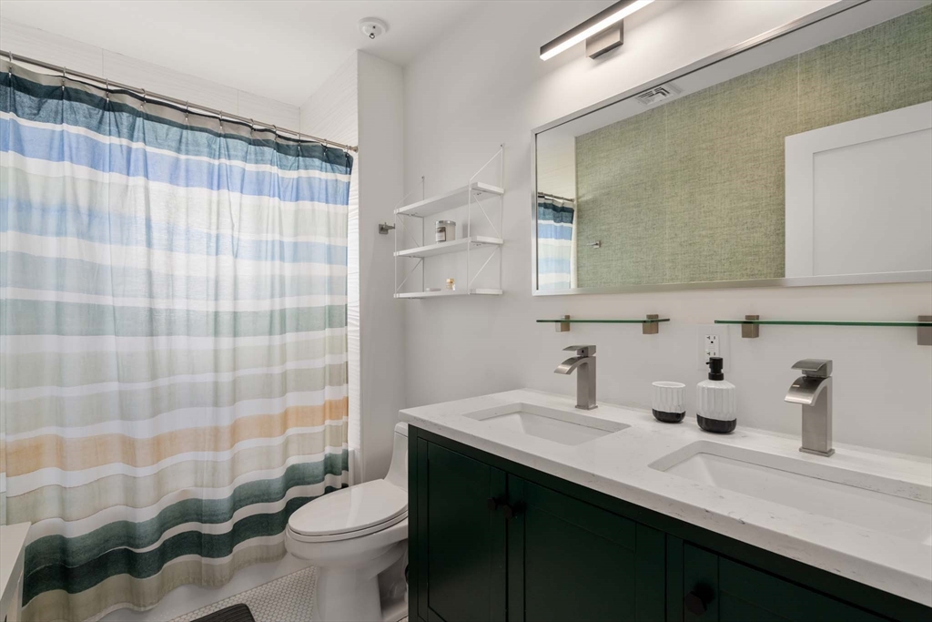 69 Henderson Street Needham, MA 02492 - Photo 17 of 26 a bathroom with a sink a toilet and shower curtain