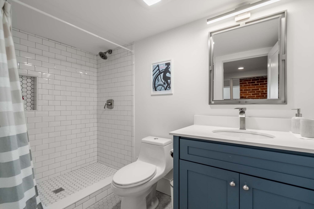 69 Henderson Street Needham, MA 02492 - Photo 23 of 26 a bathroom with a toilet sink and mirror