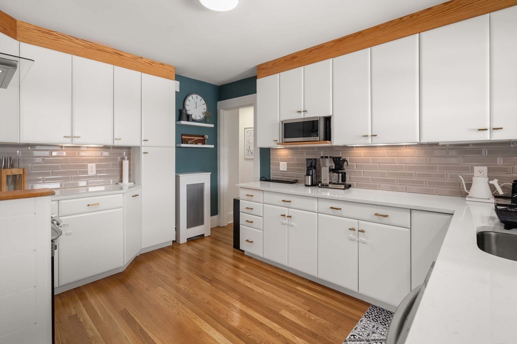 69 Henderson Street Needham, MA 02492 - Photo 9 of 26 a kitchen with granite countertop white cabinets and white appliances