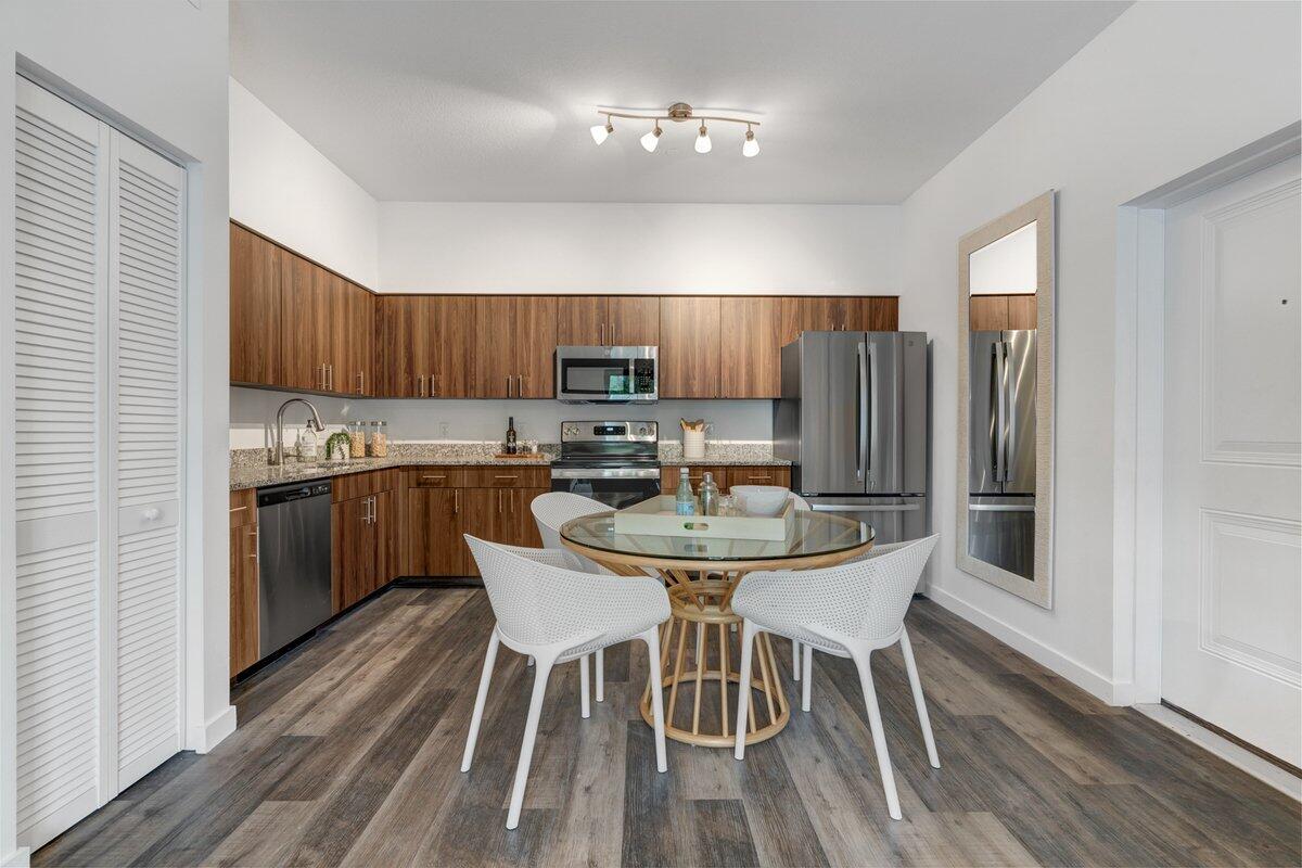 4250 Lakewood Road, Unit 101 Palm Springs, FL 33461 - Photo 4 of 20 a kitchen with granite countertop wooden floors a center island and stainless steel appliances
