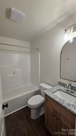 a bathroom with a granite countertop toilet a sink and a bathtub