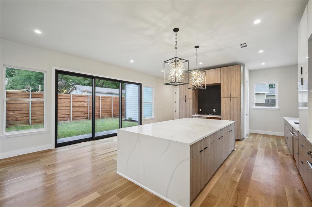 3902 Park Lane Dallas, TX 75220 - Photo 9 of 36 a large kitchen with kitchen island a large counter top a refrigerator and wooden floor