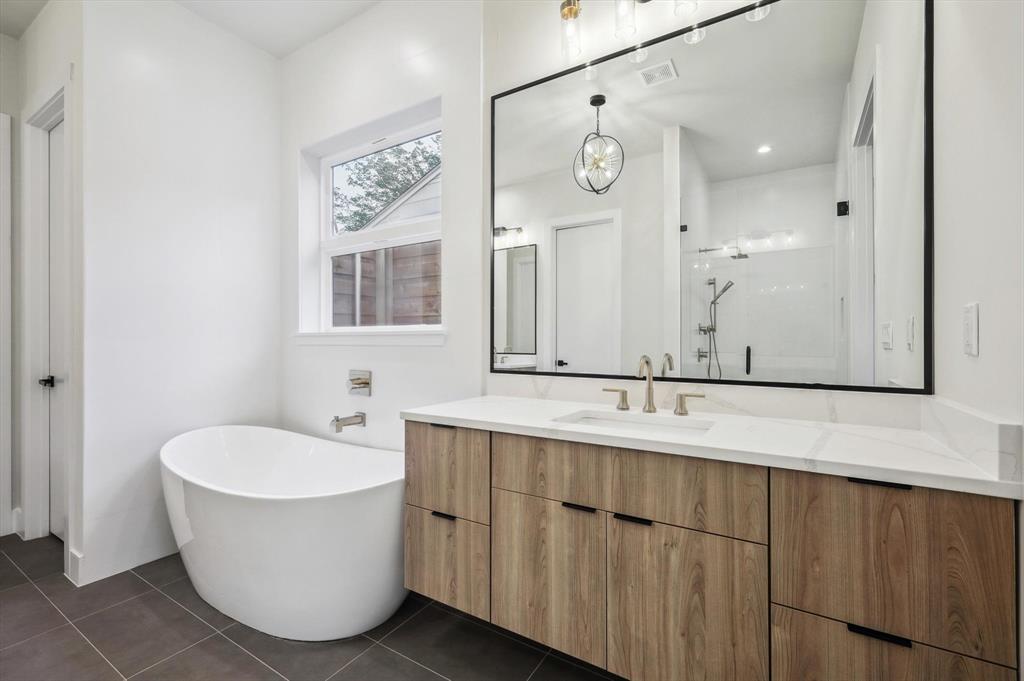 3902 Park Lane Dallas, TX 75220 - Photo 14 of 36 a bathroom with a sink a mirror and a bathtub