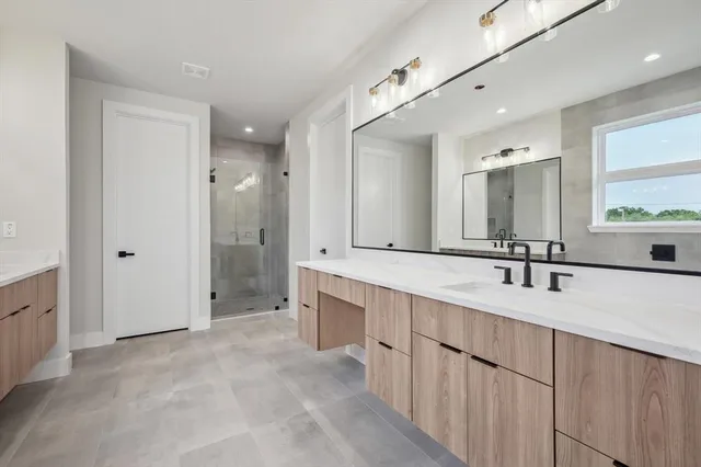 a bathroom with a tub a sink double vanity and a mirror