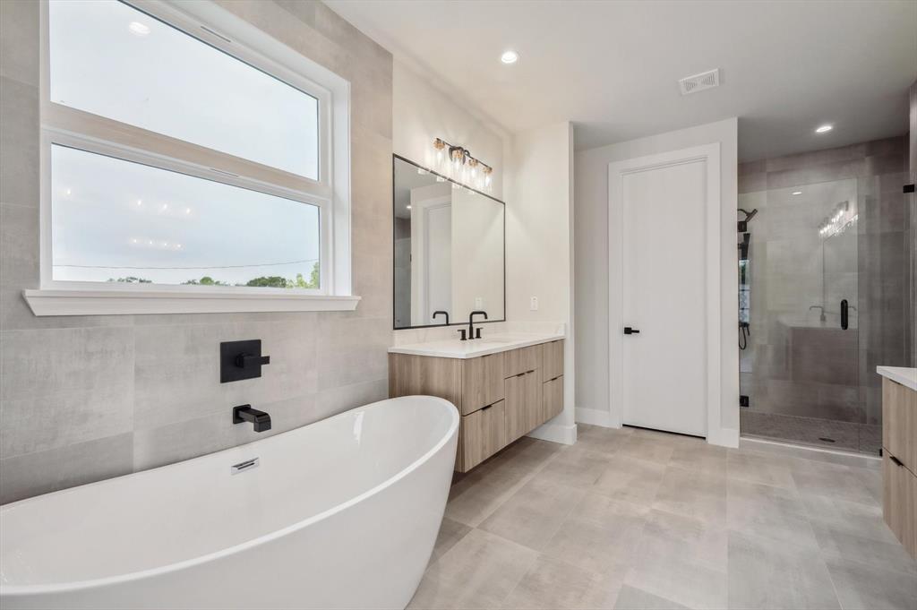 3902 Park Lane Dallas, TX 75220 - Photo 21 of 36 a bathroom with a tub a sink and a large mirror
