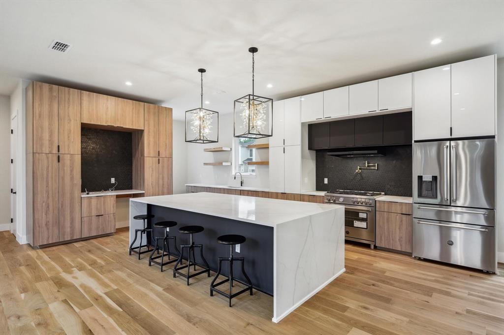 3902 Park Lane Dallas, TX 75220 - Photo 5 of 36 a kitchen with kitchen island a counter top a stove a sink and a refrigerator