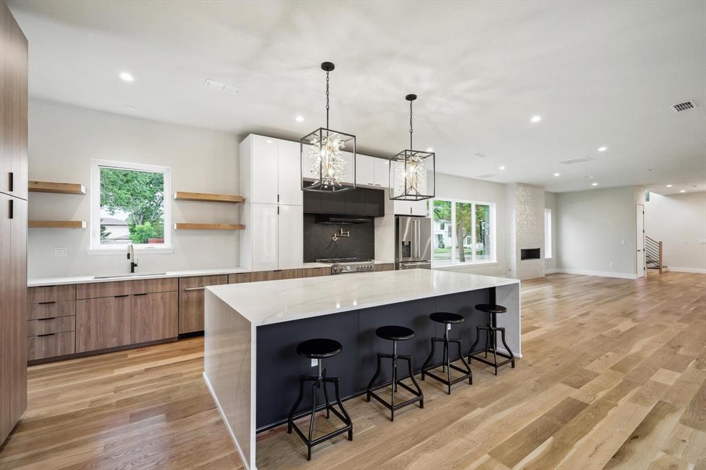 3902 Park Lane Dallas, TX 75220 - Photo 7 of 36 a kitchen with stainless steel appliances granite countertop a kitchen island hardwood floor sink stove dining table and chairs