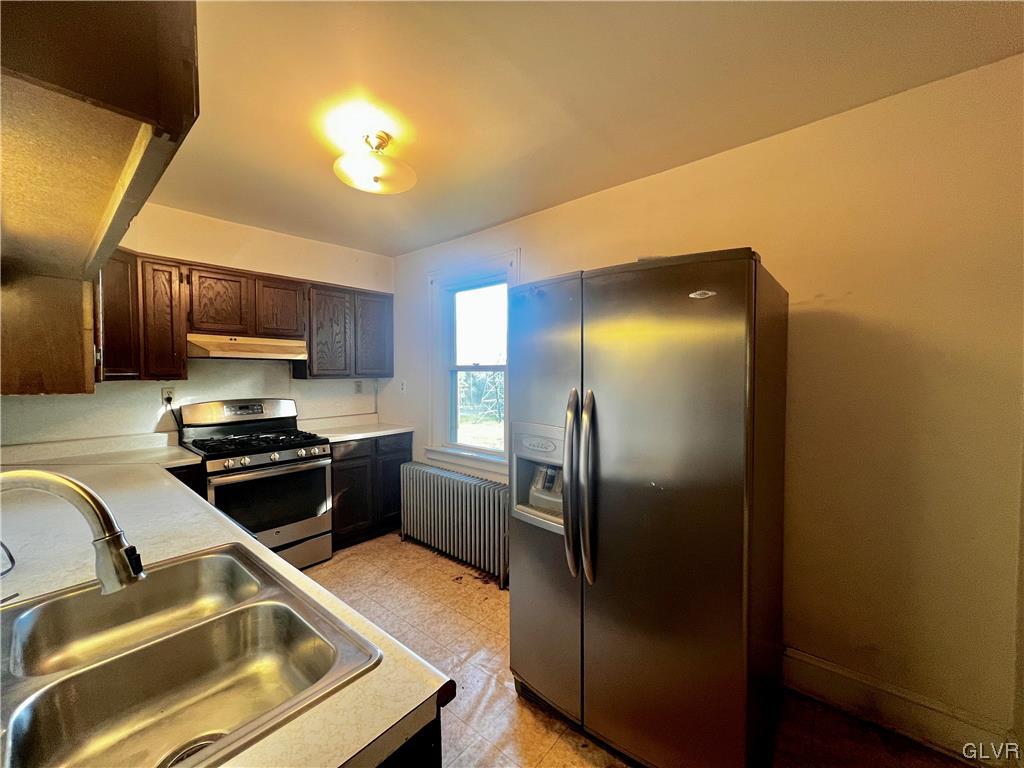 705 Main Street Stockertown, PA 18083 - Photo 8 of 23 a kitchen with stainless steel appliances granite countertop a refrigerator a stove and a sink with wooden floor